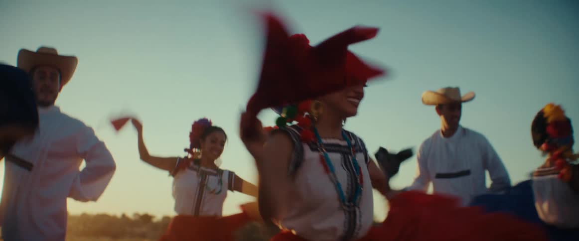 Group of dancers performing a traditional latin american folk dance outdoors at sunset