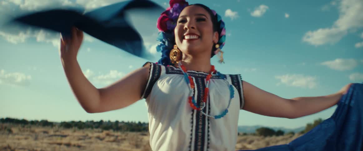 Happy woman performing a traditional latin american folk dance outdoors at sunset