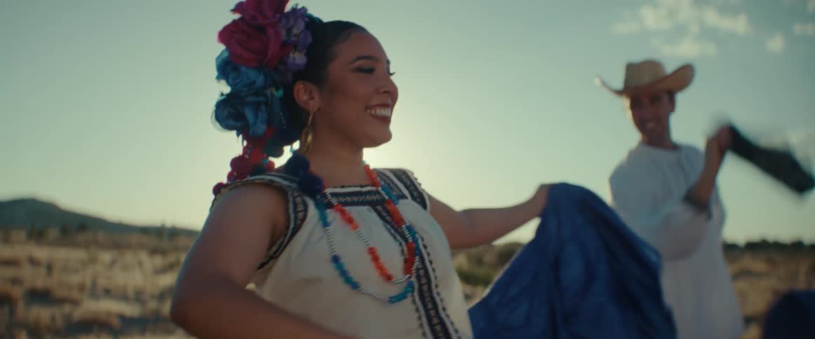 A man and woman are dancing with flags in traditional outfits