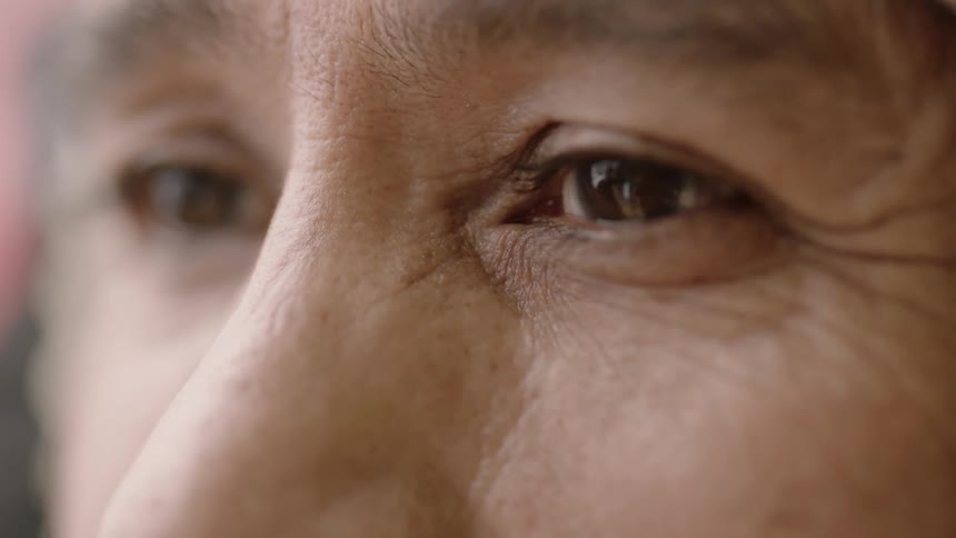A person blinks their eyes looking forward
