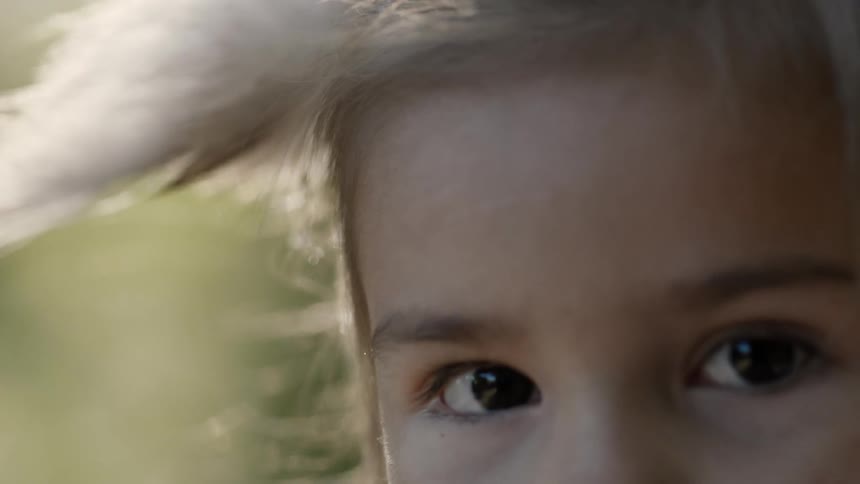 Young girl looking into the camera as the wind gently blows her hair