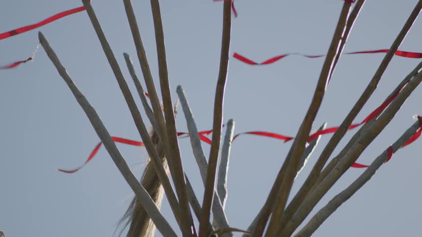 Red flags flying high on top of wooden poles