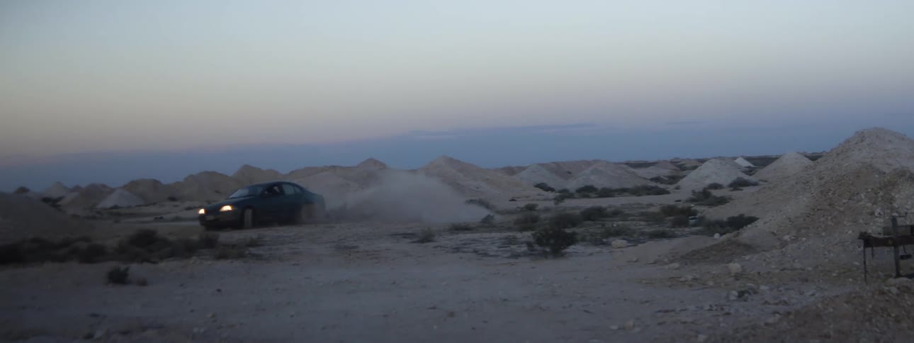A car is driving in the desert