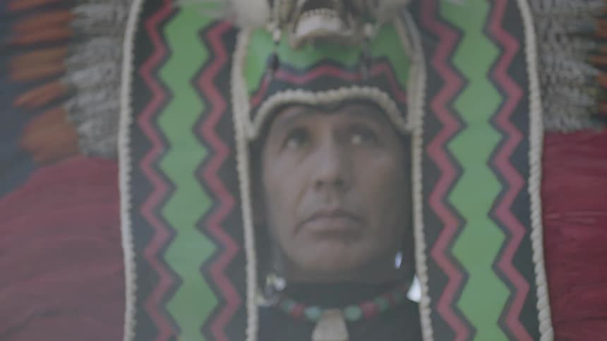 Man places elaborate headpiece on his head