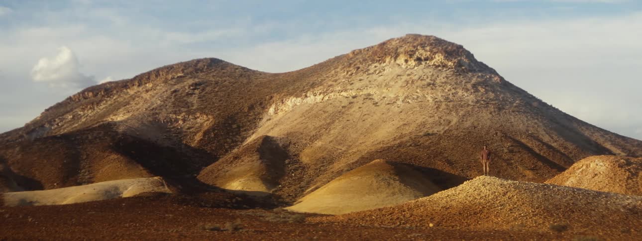 A person is standing on the hill in the distance