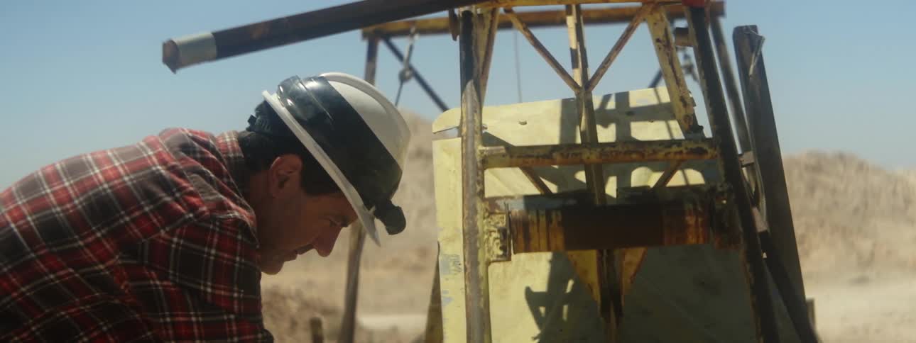 A man wears a hard hat while working on a oil rig