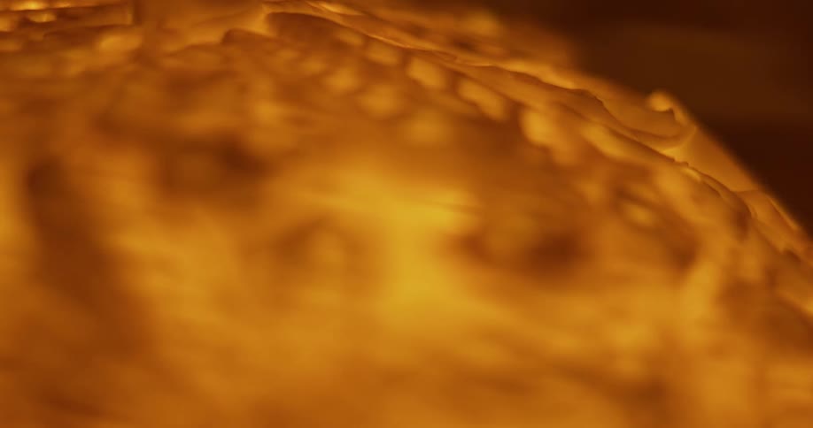 Orange glowing surface of ember contrasts with darker background