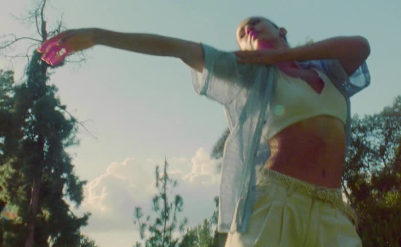 A woman dances outdoors on a sunny day