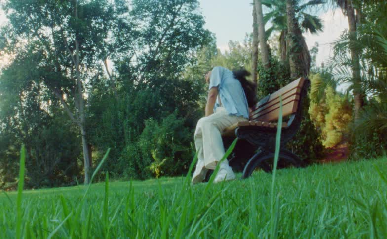Woman dances on bench in park
