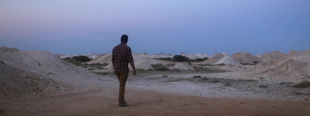 A man walks across a desert