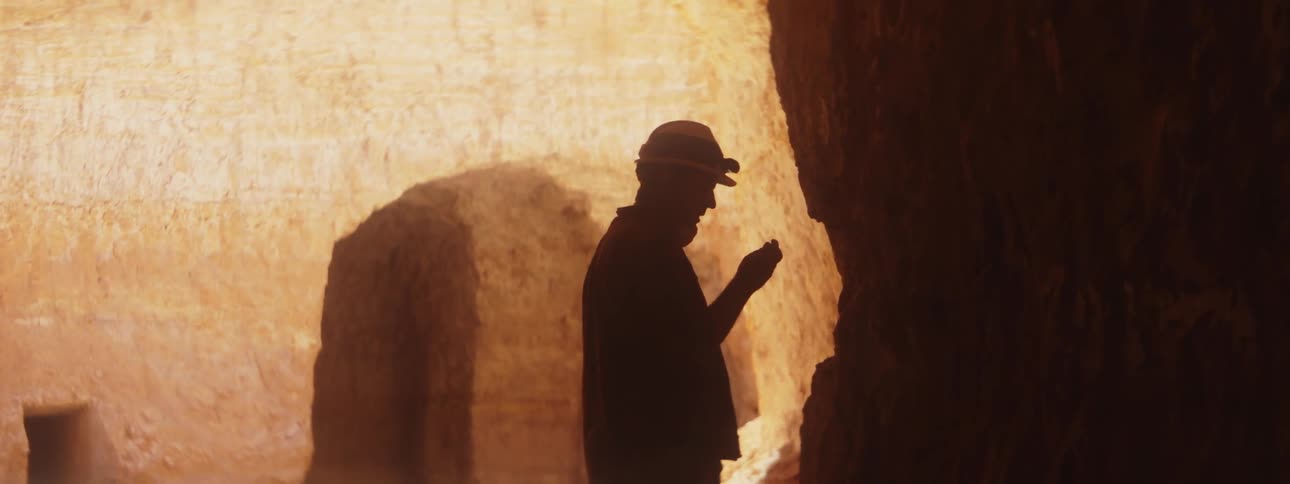 A man wears a headlamp inside a cave