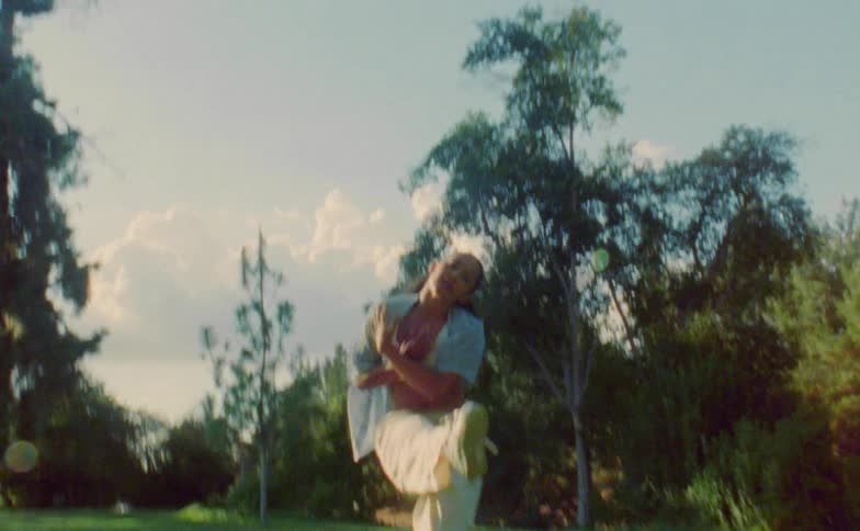 A woman dances in a field