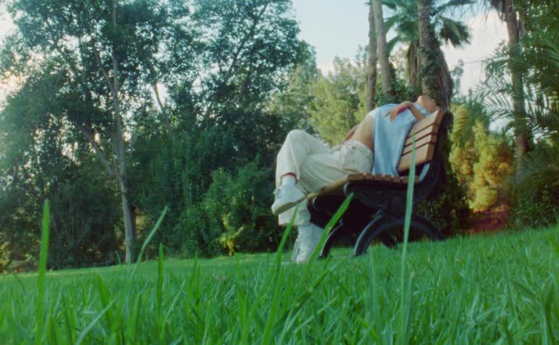 A woman kicks on the park bench