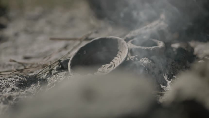 Ashes and other objects smoking on the ground during the day