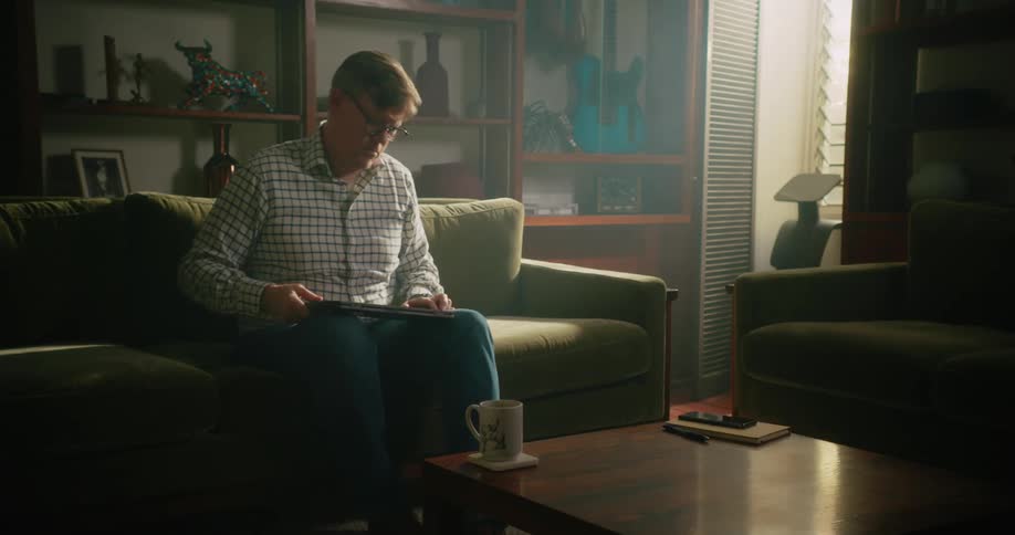 Man places smartphone and laptop on the coffee table before standing