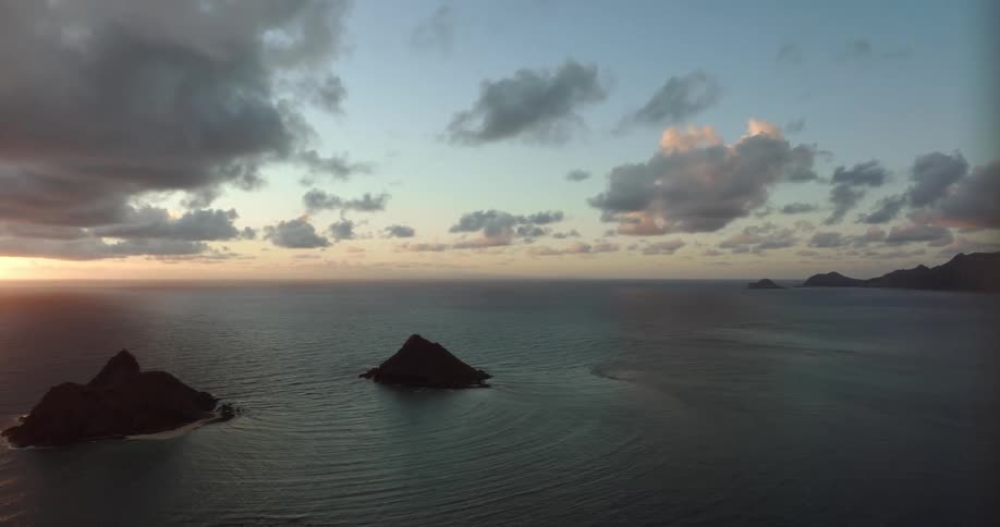 Sun on red horizon shines over islands and town sitting on shore