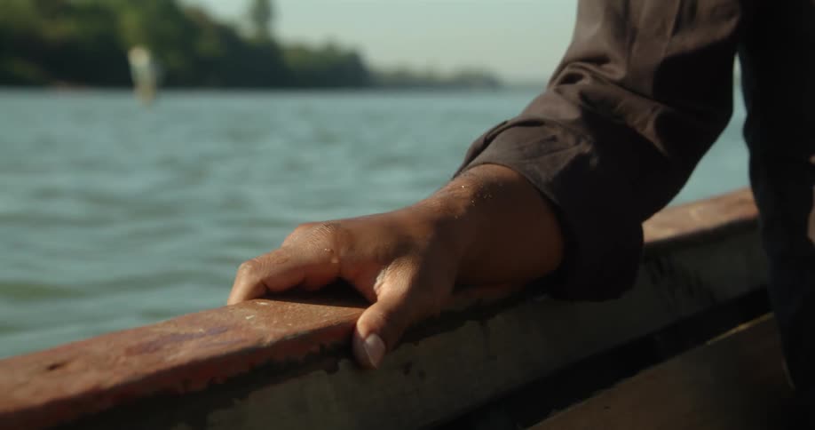 A man is on a boat as it goes across rough water