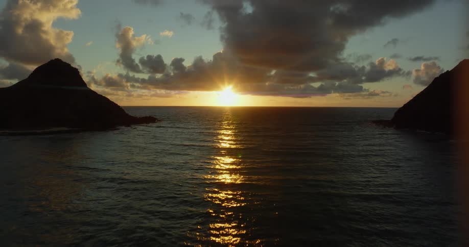 The sun sets over small islands in the ocean