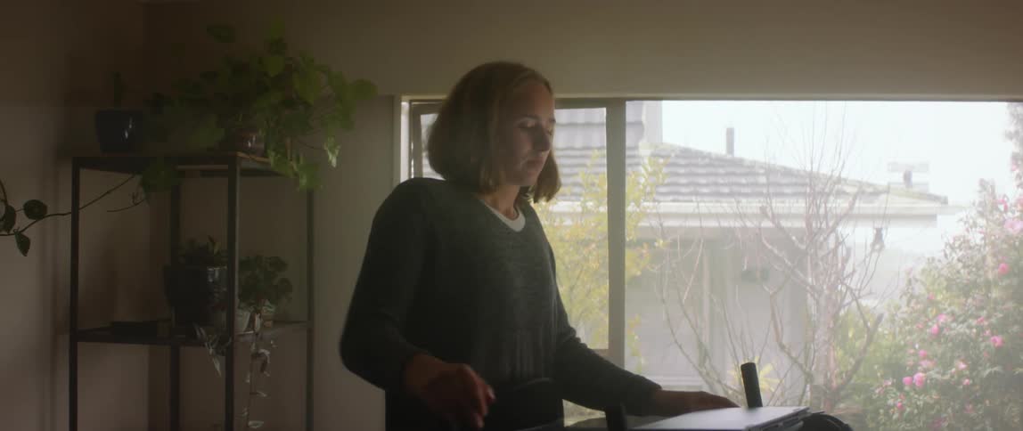 A woman opens her laptop and types