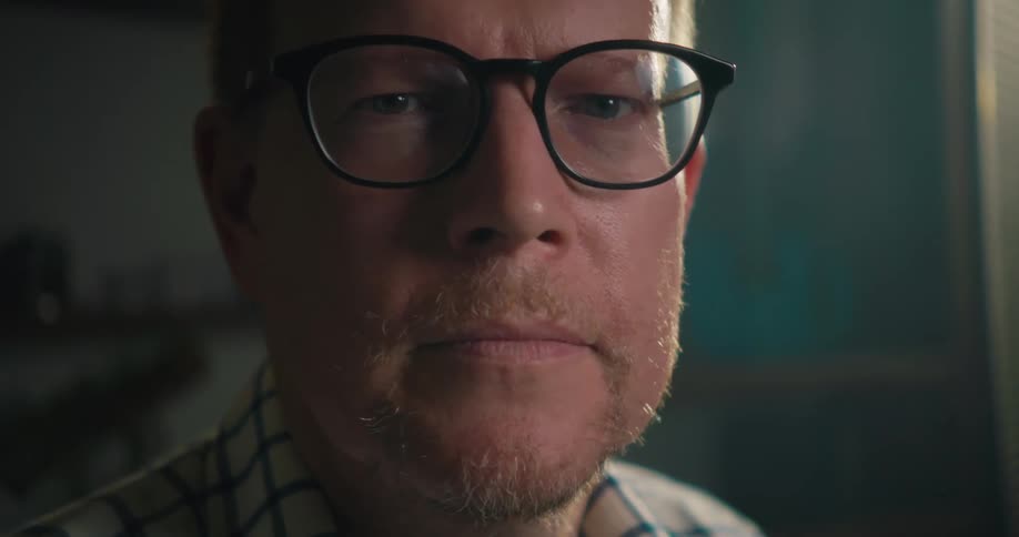 Man wearing eyeglasses turns his head to look