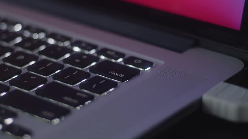 Person hits delete key on laptop keyboard
