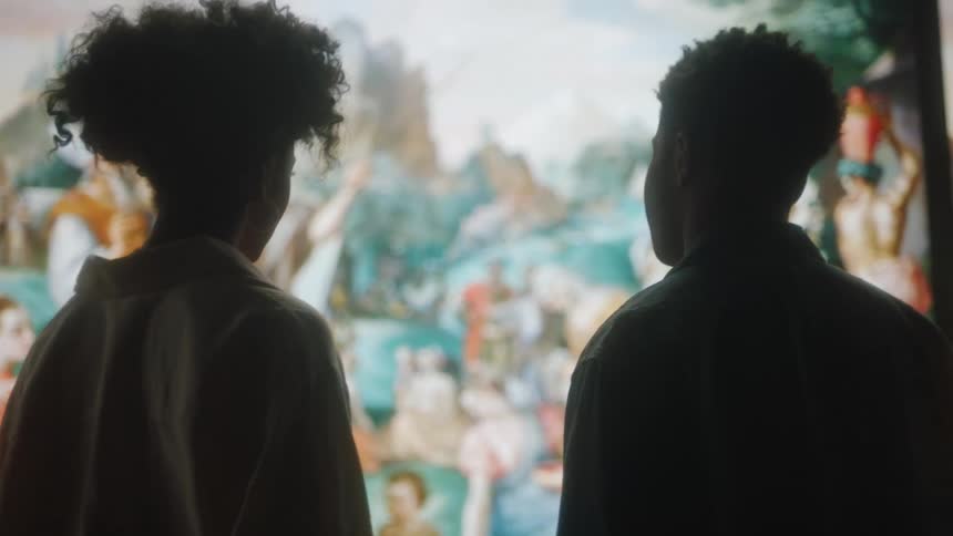 Man andwoman stand in front of large painting talking