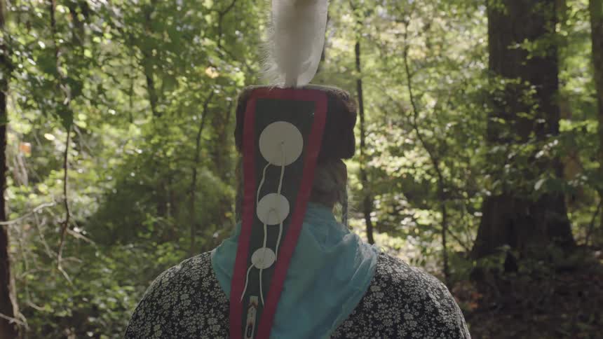Tribal man walking through a sunny forest
