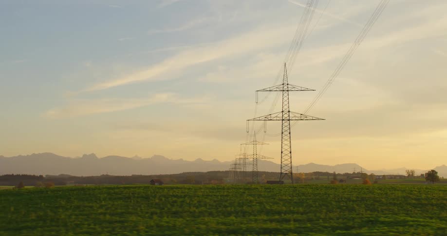 Electrical lines running above a rural field at sunrise