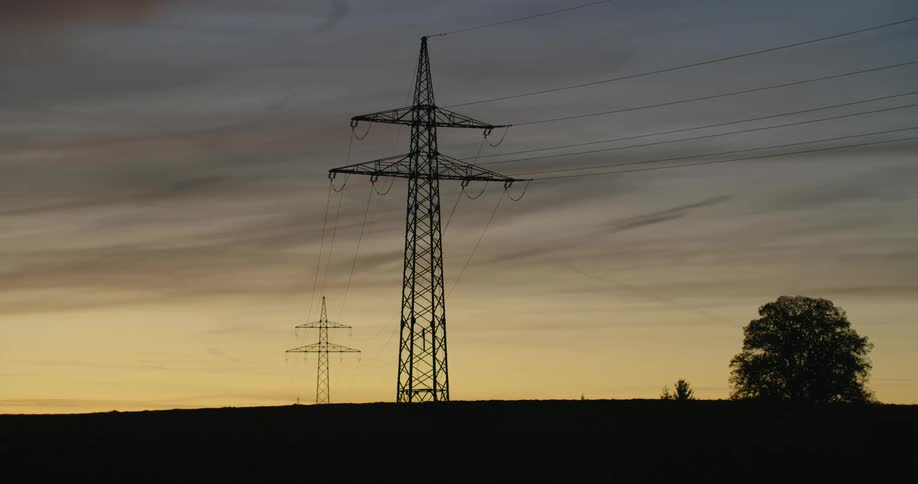 Silhouette of a transmission tower on the countryside at evening