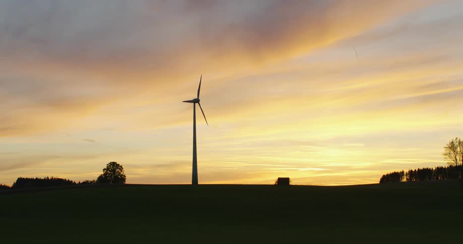 The sun is rising on the windmill