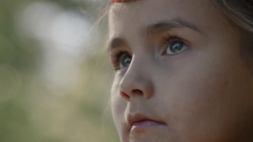 A young girl stares straight ahead