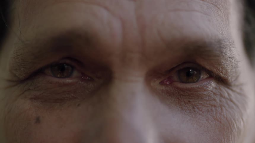 A man blinks and looks forward