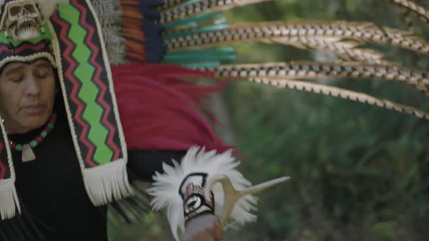 A man is dancing with a skull on his headdress