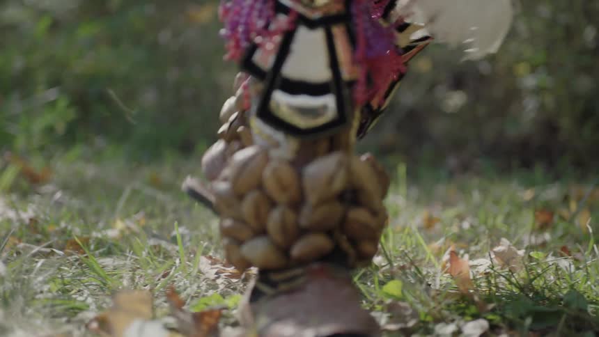 A tribesman dances around on leaves