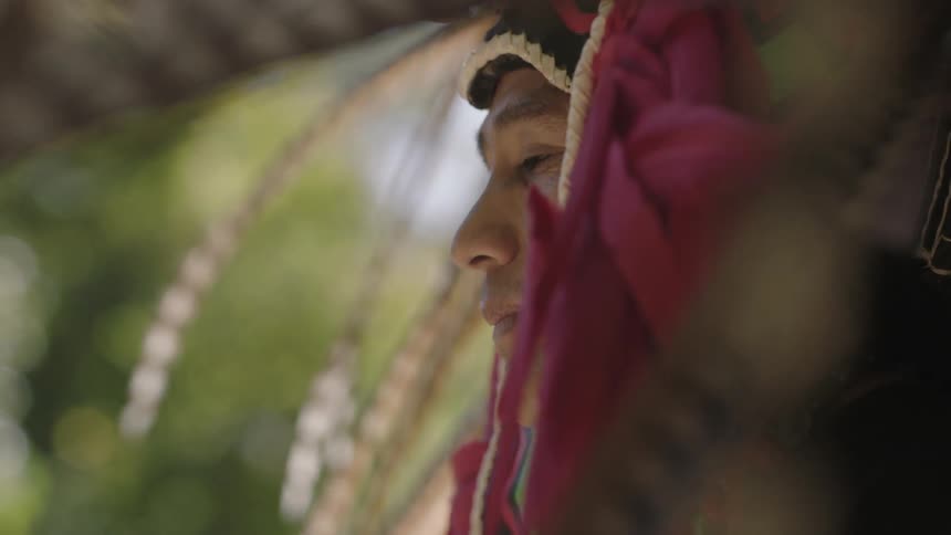 A man in a headdress looks around