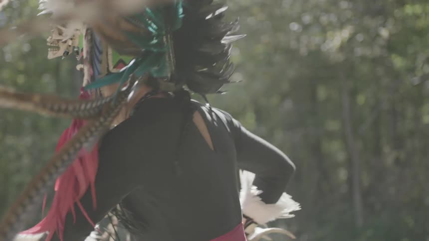 A man dances around in a headdress