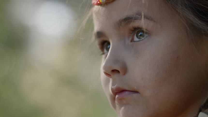A little blonde girl looks upward