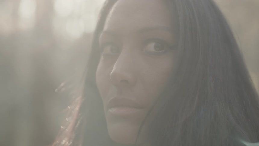 Woman looking cautiously around in a smoky forest