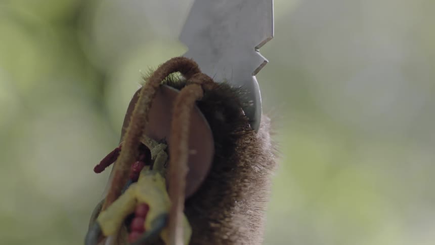 Close-up of the tip of a spear then moving downward