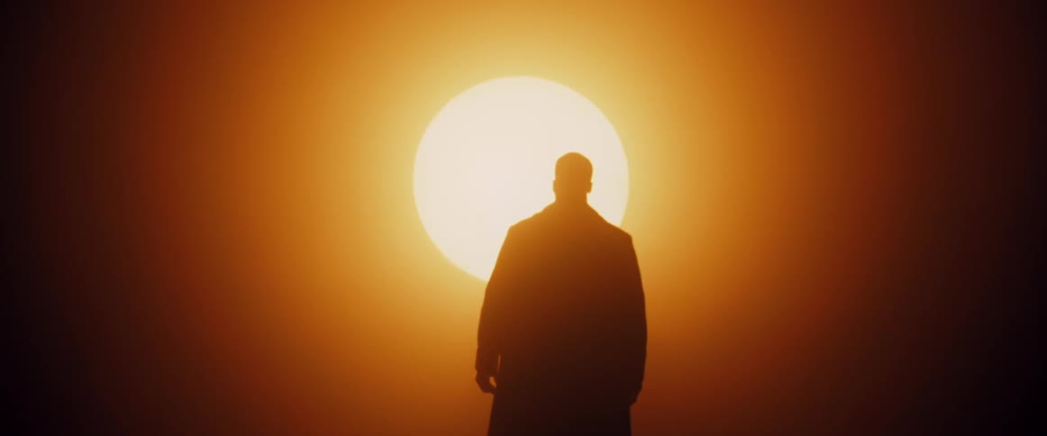 A man walks towards the bright sun