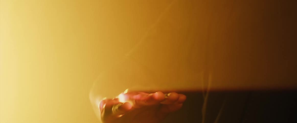 A person moves their hand through the light