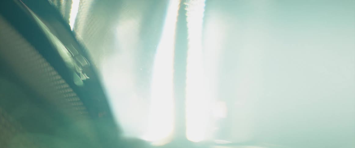 Close up of the bright lights headlights of a car turning on surrounded by white smoke blown by the wind