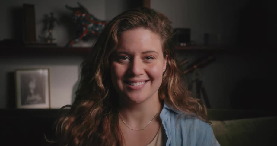 A teenage girl laughs and smiles at home