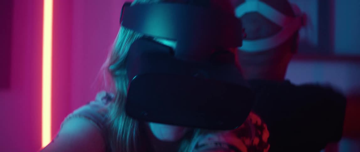 Man and woman wearing virtual reality headsets game with a game controller
