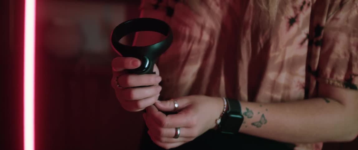 A woman straps on a gaming device to her arm