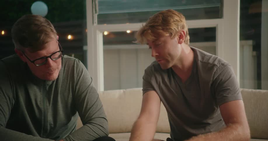Two friends are sitting on a couch and talking together