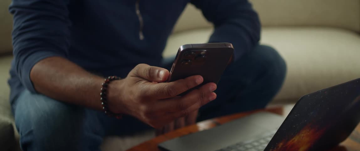 A man waving at a smartphone during a video call