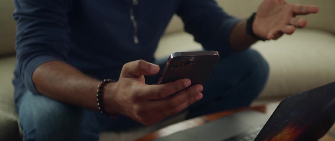 Man sitting on couch in front of laptop gestures while making a video call