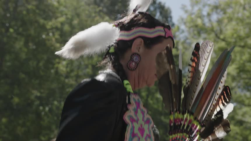 A woman in a native american costume dances