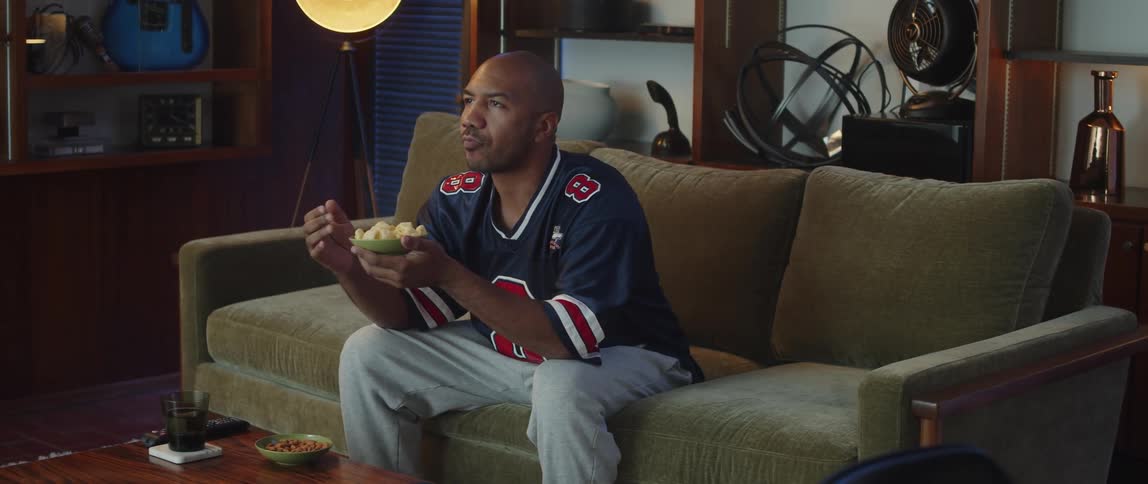 A person is sitting on a couch and eating